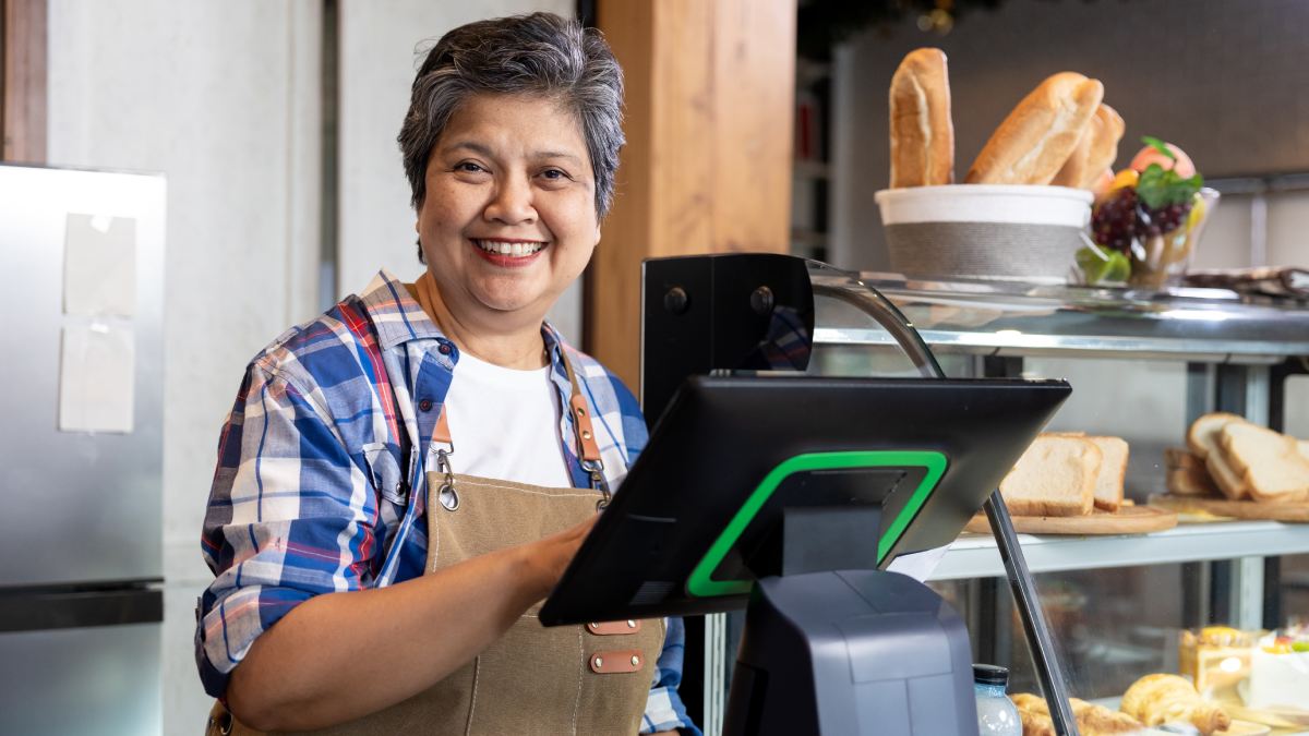 Caisse enregistreuse dans une boulangerie avec une employée qui travaille.