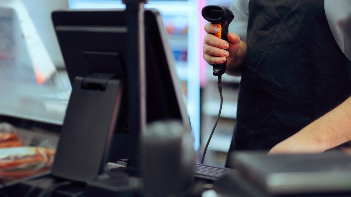 Caisse enregistreuse avec douchette pour scanner les articles dans un commerce.