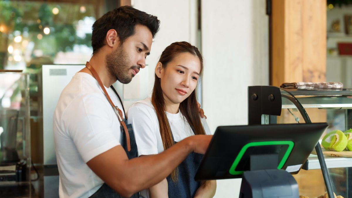 Couple propriétaire d'un petit café familial, un homme enseigne un travail à une femme. Pour comprendre l'utilisation des caisses enregistreuses Devant le comptoir du café, une femme est déterminée à apprendre.