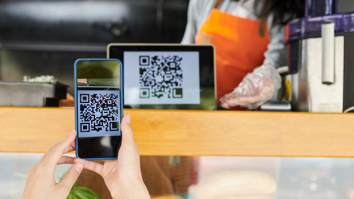 Client payant par QR code avec son smartphone dans un magasin.