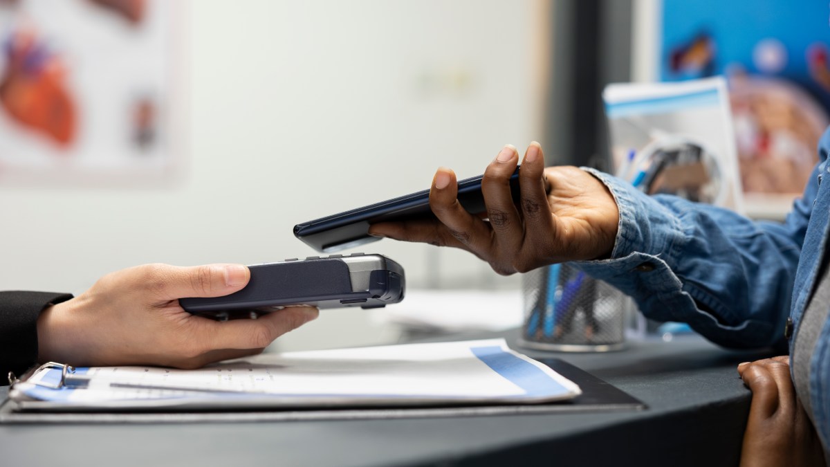 Gros plan sur une transaction de paiement sans contact avec smartphone dans un magasin.