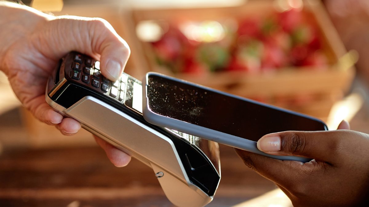 Client payant avec son smartphone sur un terminal de paiement mobile.