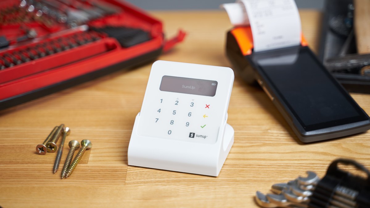 Terminal de paiement SumUp avec des outils et des clous autour.