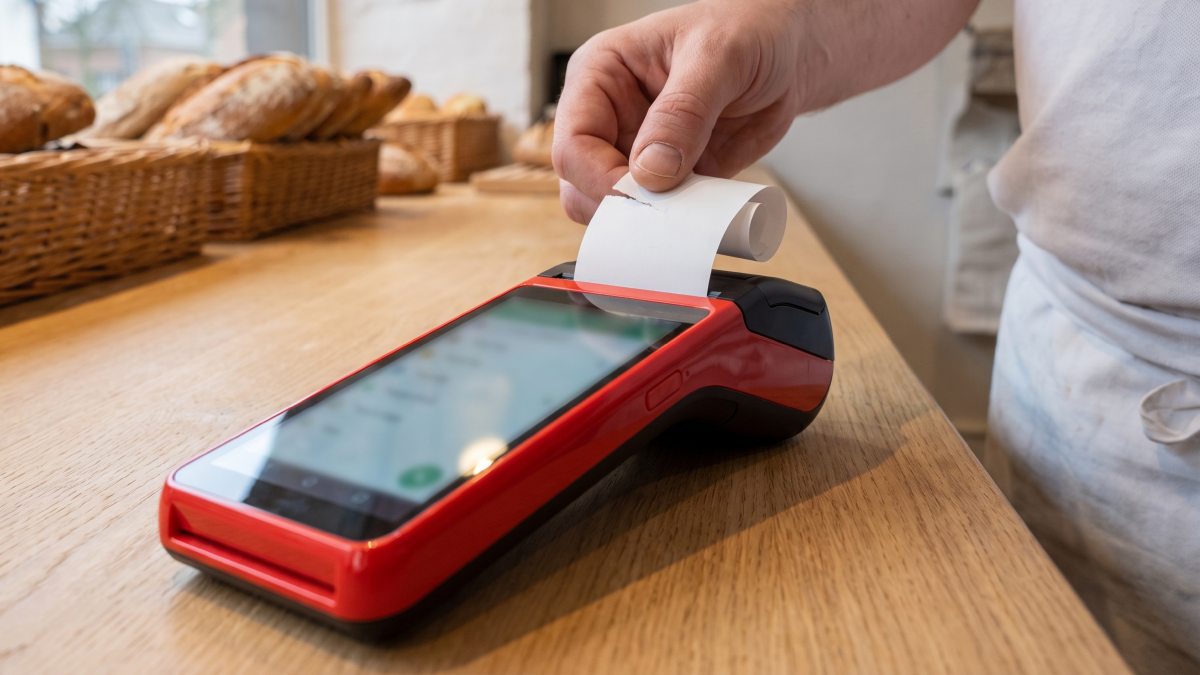 Terminal de paiement LoyalPay dans une boulangerie avec ticket.